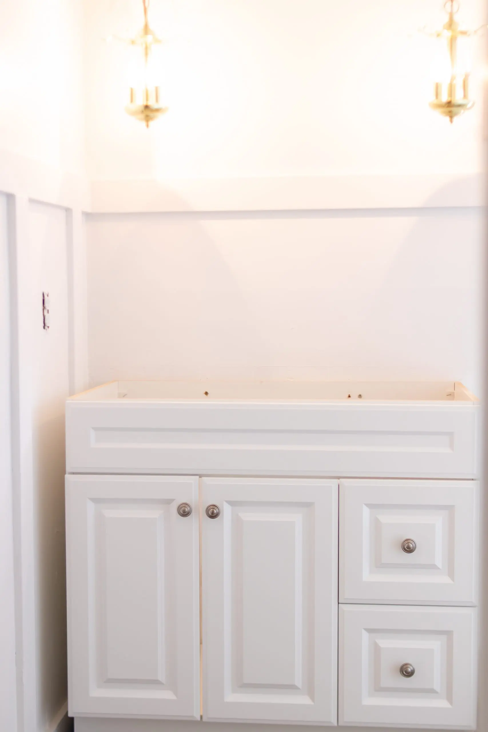 white vanity with white marble sink top old gold pendant lights